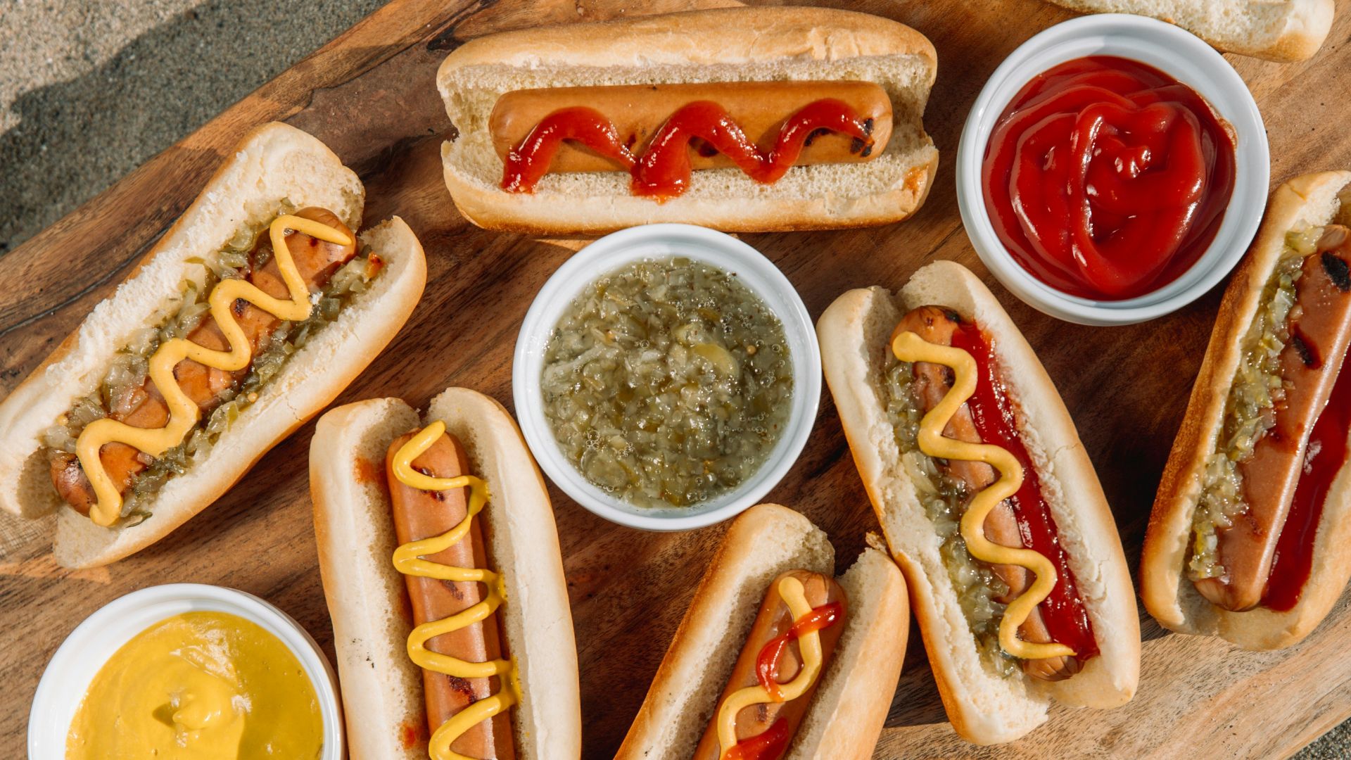 hotdog sandwich with sauce on brown wooden tray