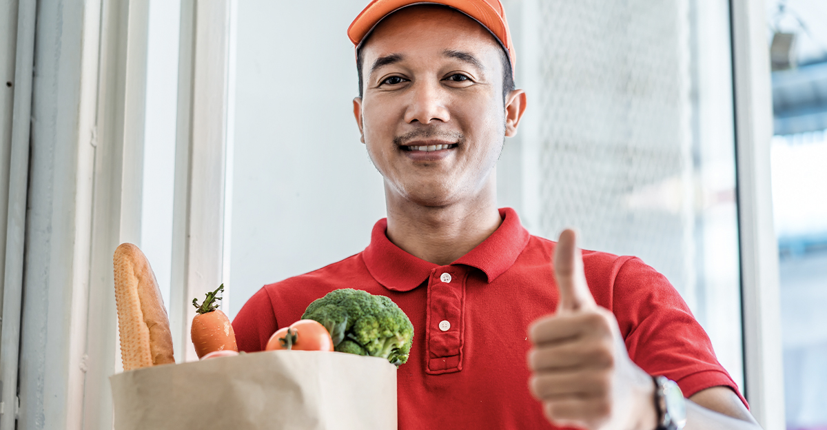 Delivery man giving a thumbs up, delivering groceries.