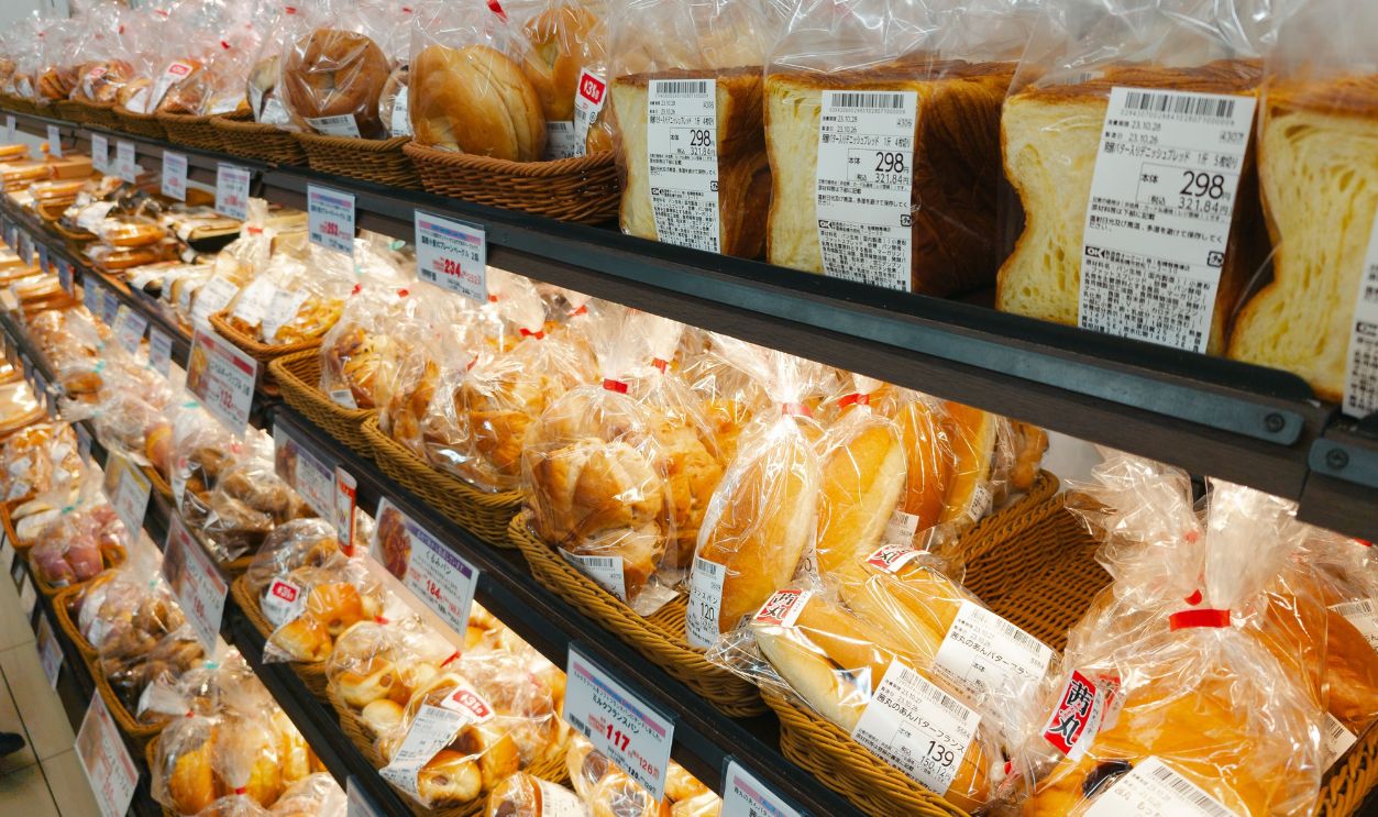A diverse selection of prepackaged bread in a grocery store aisle, perfect for food-related projects.