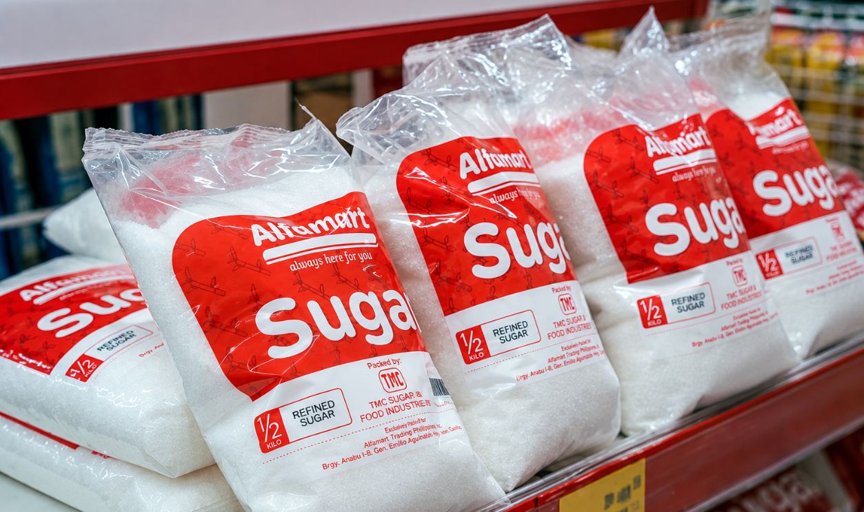 Close-up of sugar bags on a grocery store shelf, highlighting product packaging.