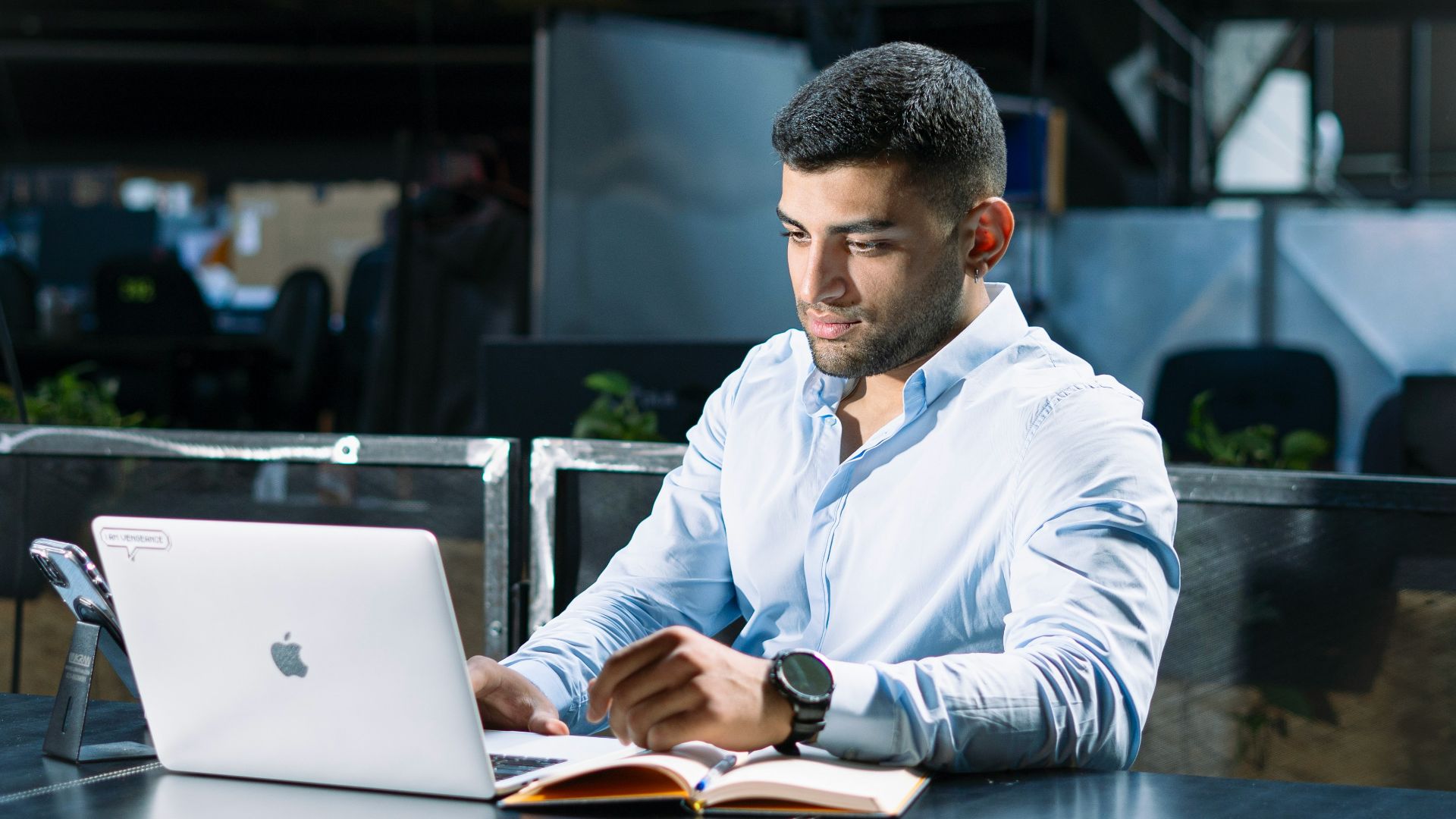 A man sitting at a table using a laptop computer