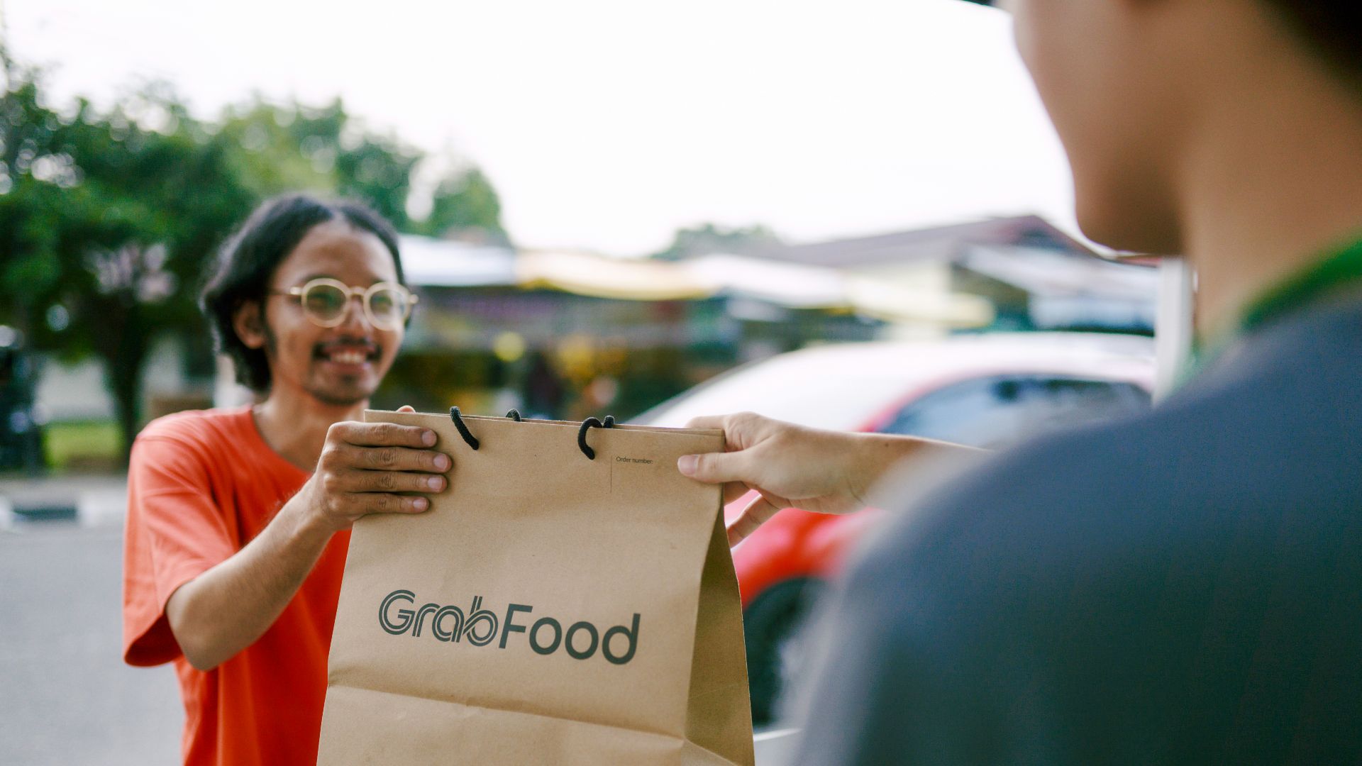 a man holding a paper bag with the word good food on it