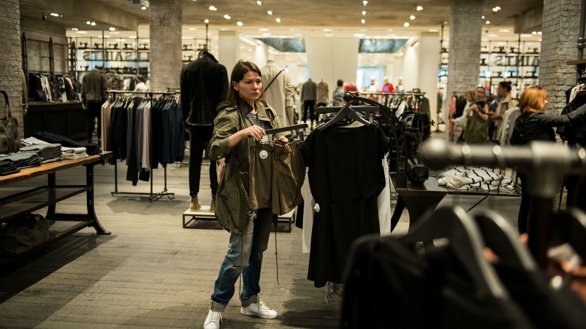 woman holding apparel inside shopping building