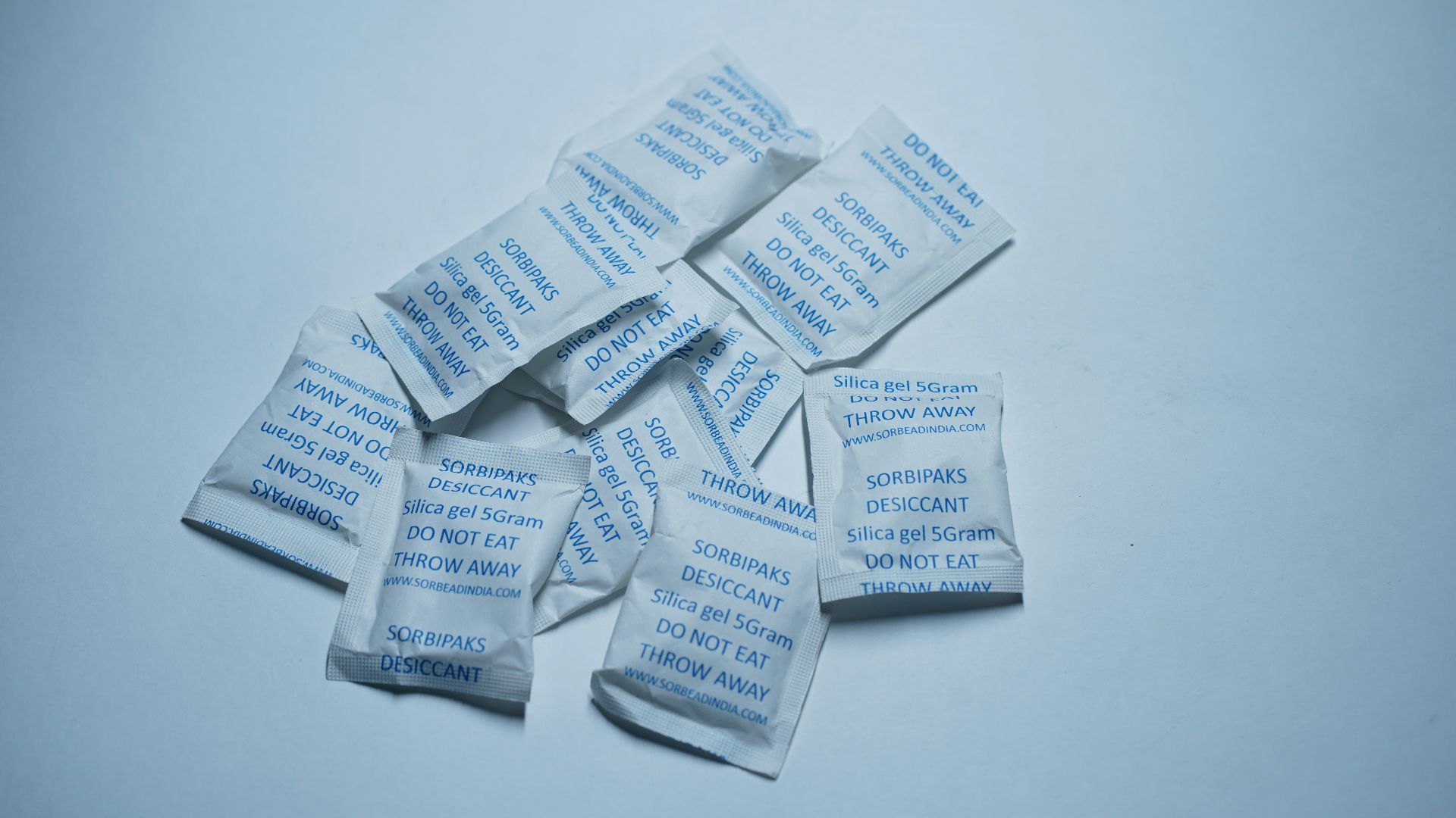 Small white packets with blue text on a light background