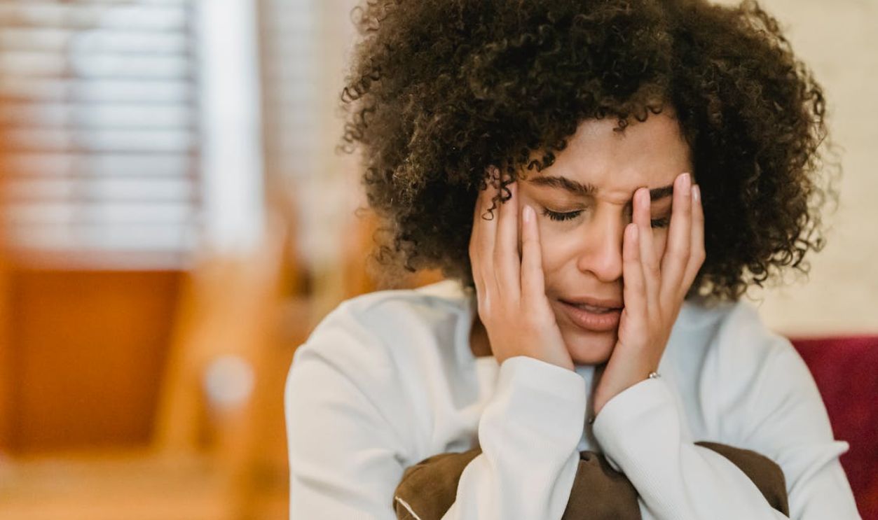 Frustrated black woman sitting in room