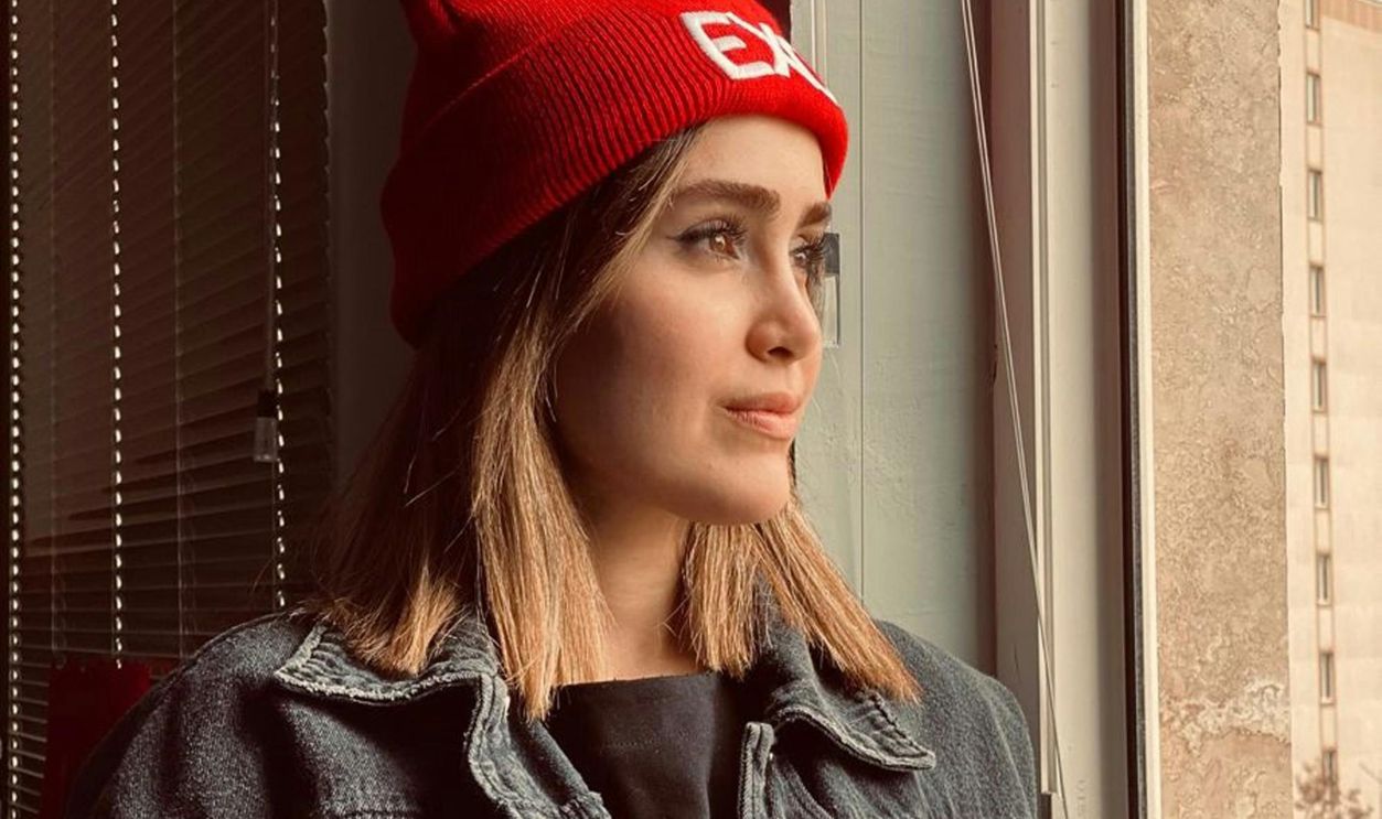 Woman Wearing a Red Knit Cap Looking Outside a Window