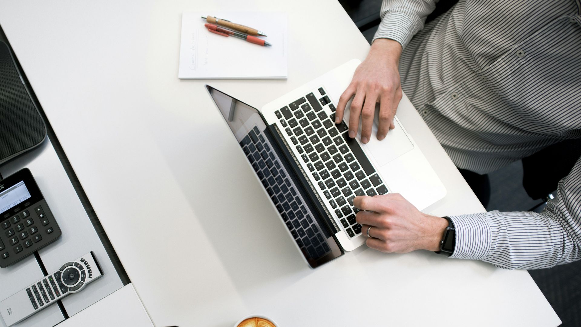person using laptop on white wooden table
