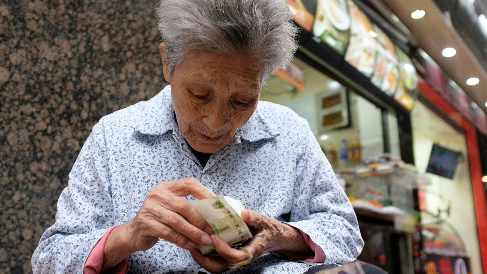 A woman sitting on a bench looking at her cell phone