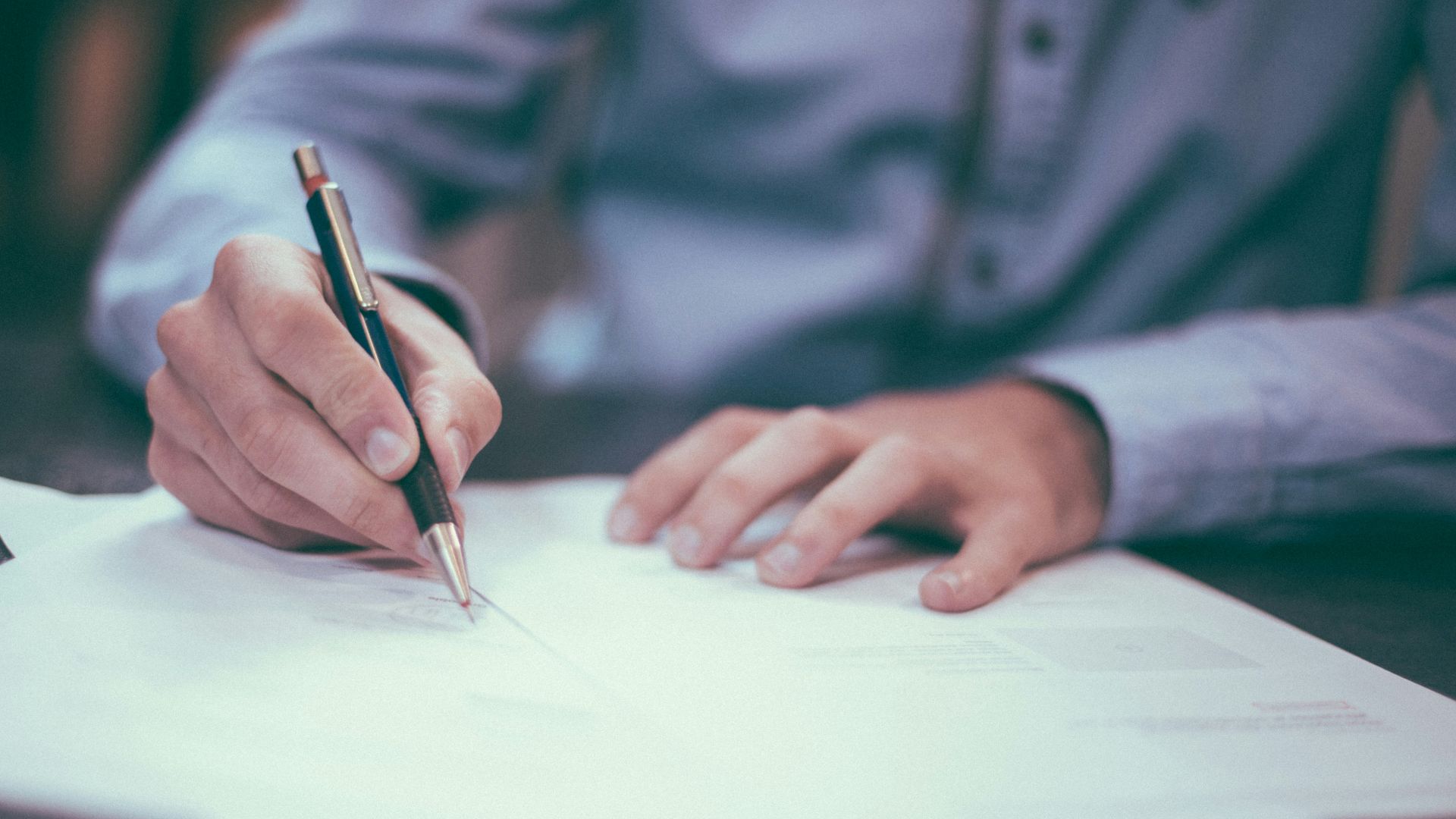 man writing on paper