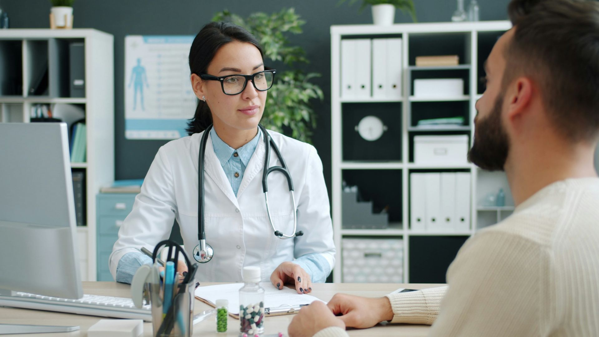 Doctor consults with patient in medical office.