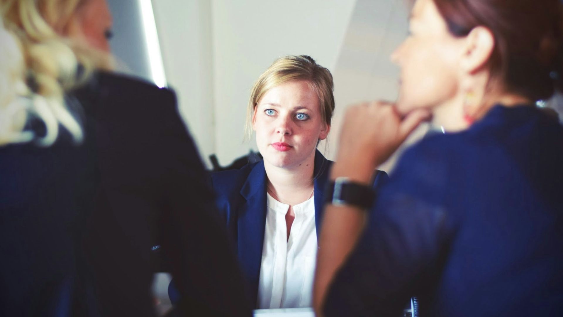 three women sitting beside table
