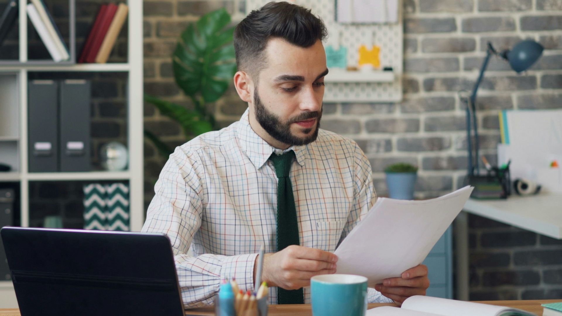 a man sitting at a desk in front of a laptop