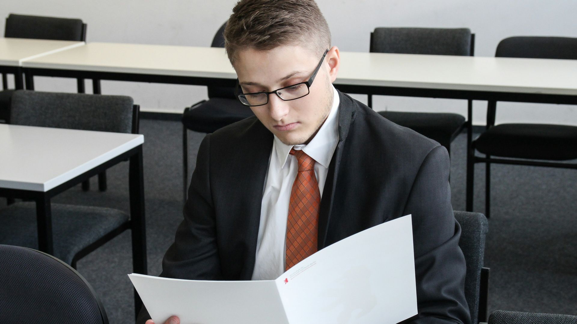 man holding folder in empty room
