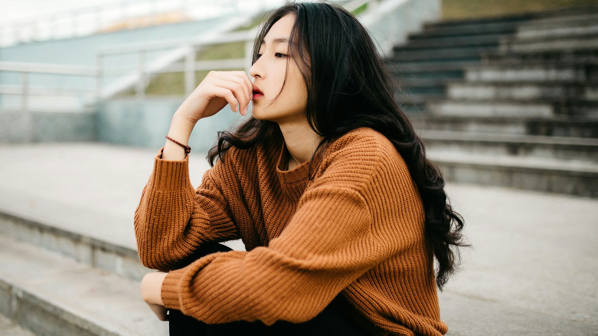 woman wearing brown sweater holding lips