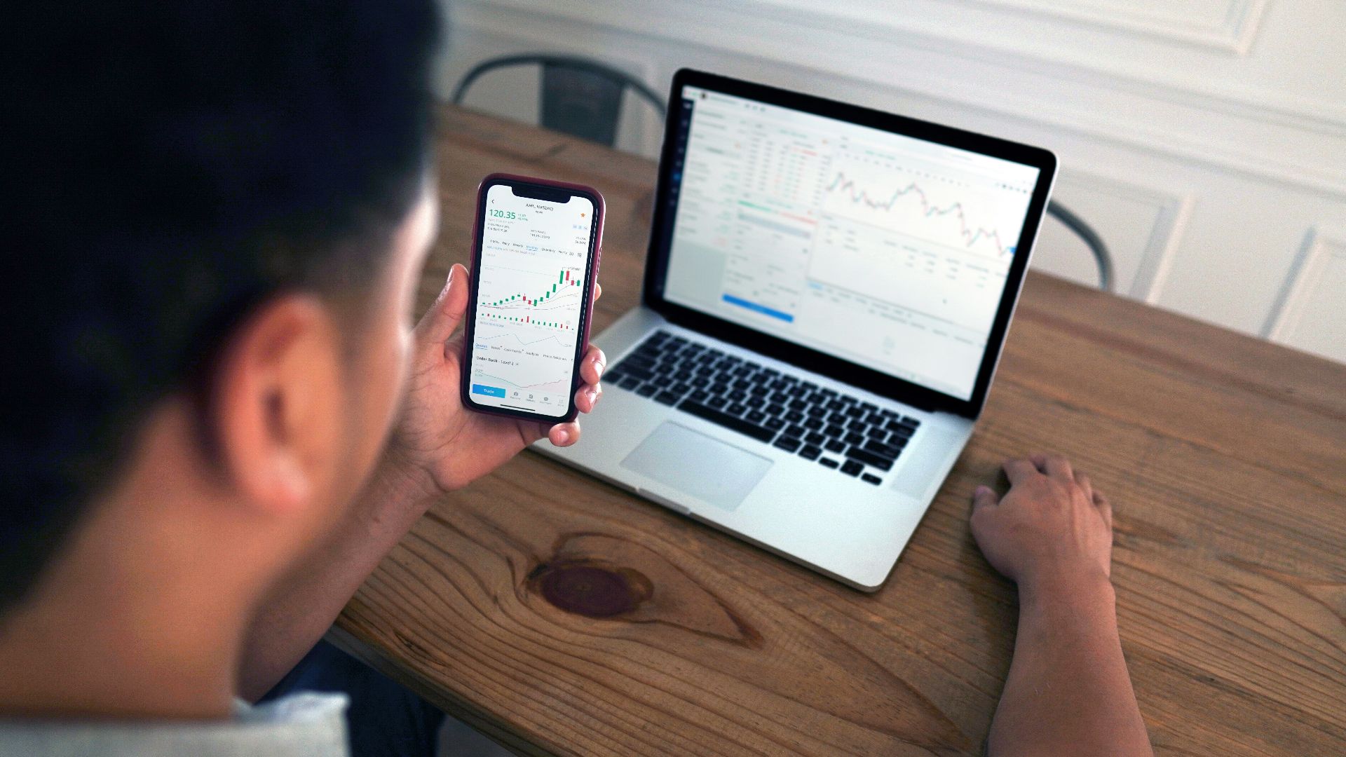 person holding iphone 6 near macbook pro