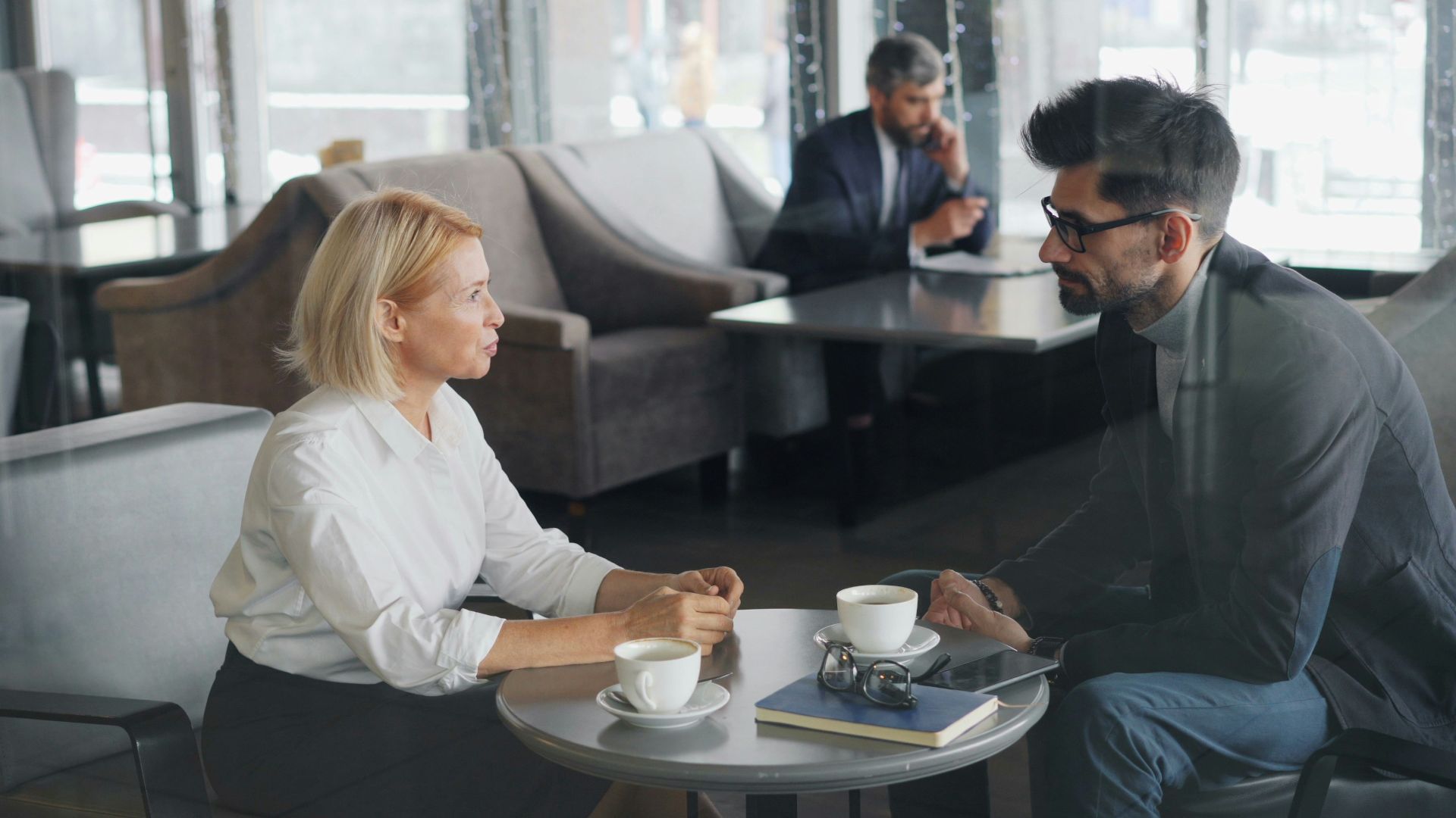 a man and a woman sitting at a table talking