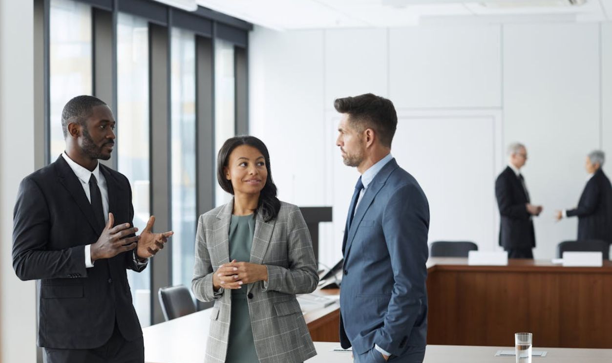 Man in Blue Suit Standing Beside Woman in Gray Blazer