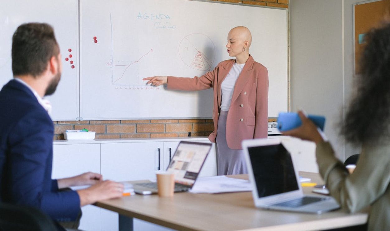 Bald woman explaining charts to colleagues