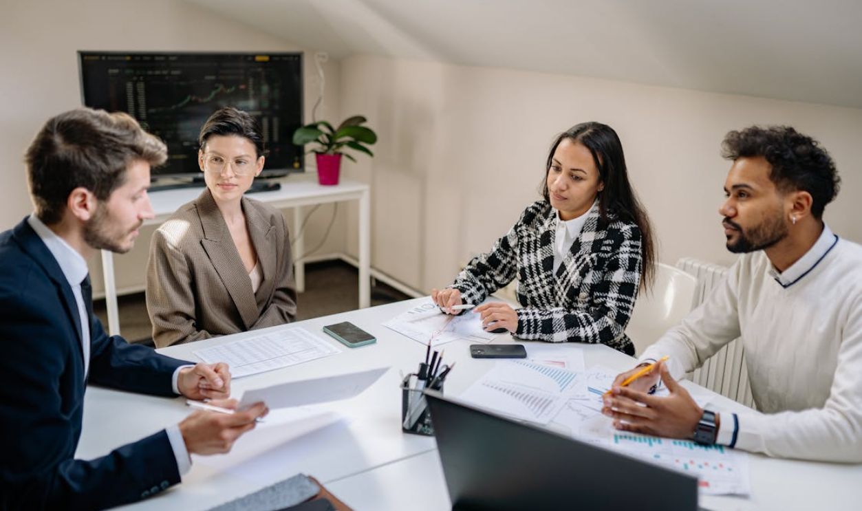 A Group of People Sitting while Discussing their Work