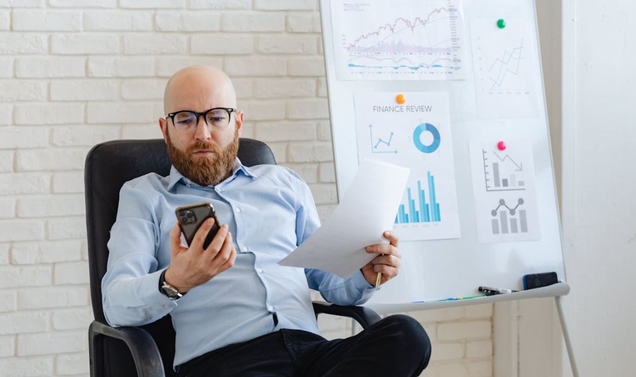 A Man in Corporate Attire Using a Cellphone