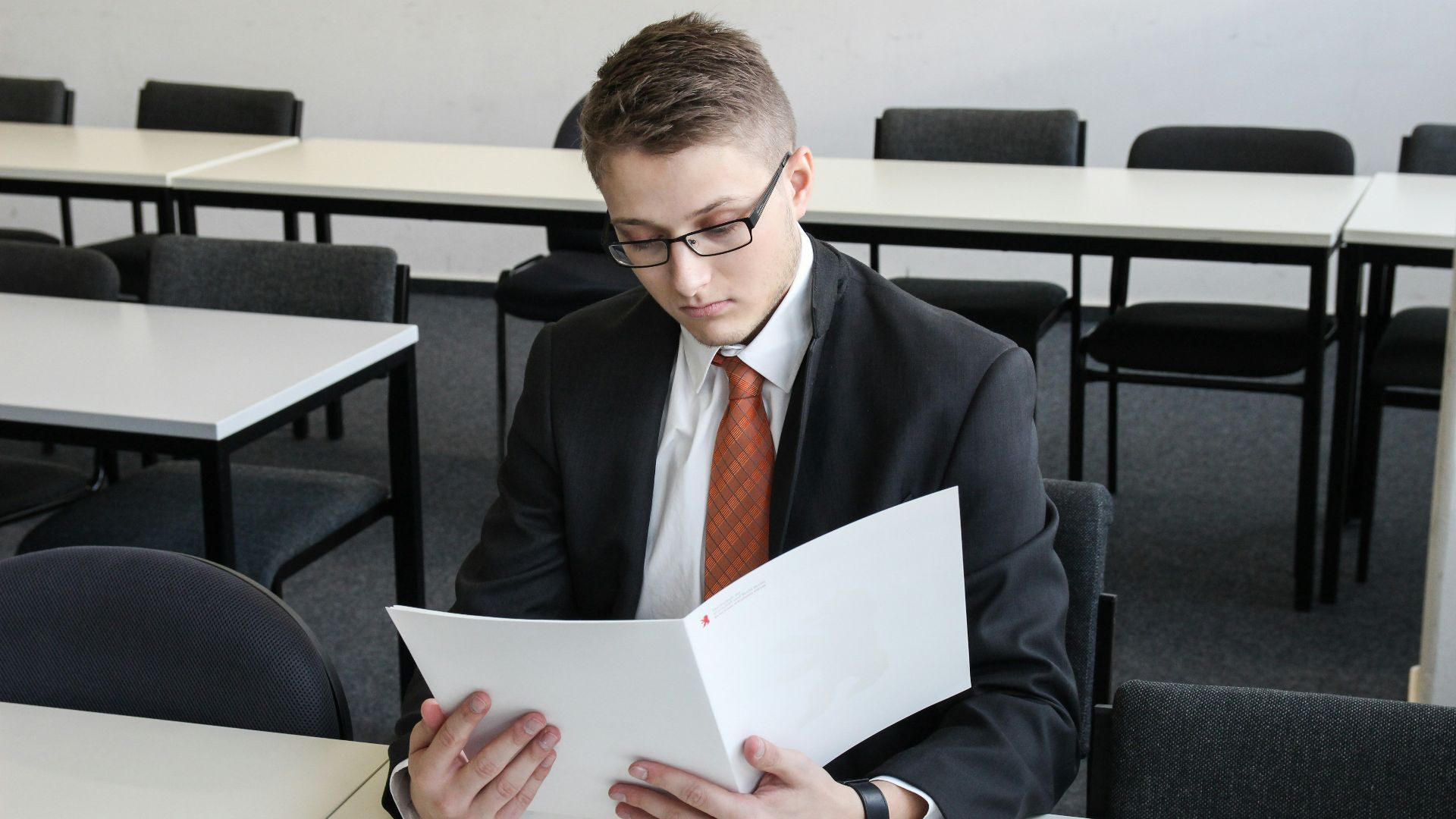 man holding folder in empty room