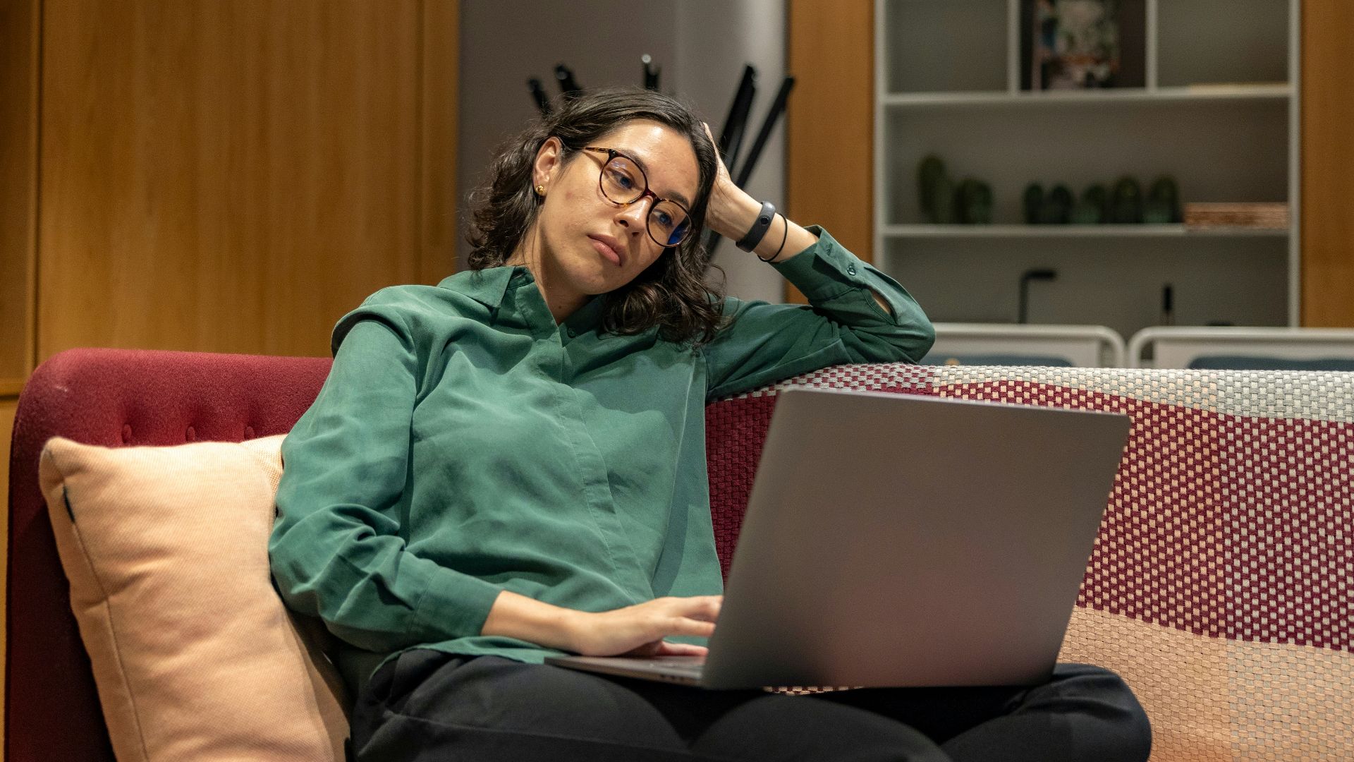 a woman sitting on a couch using a laptop computer