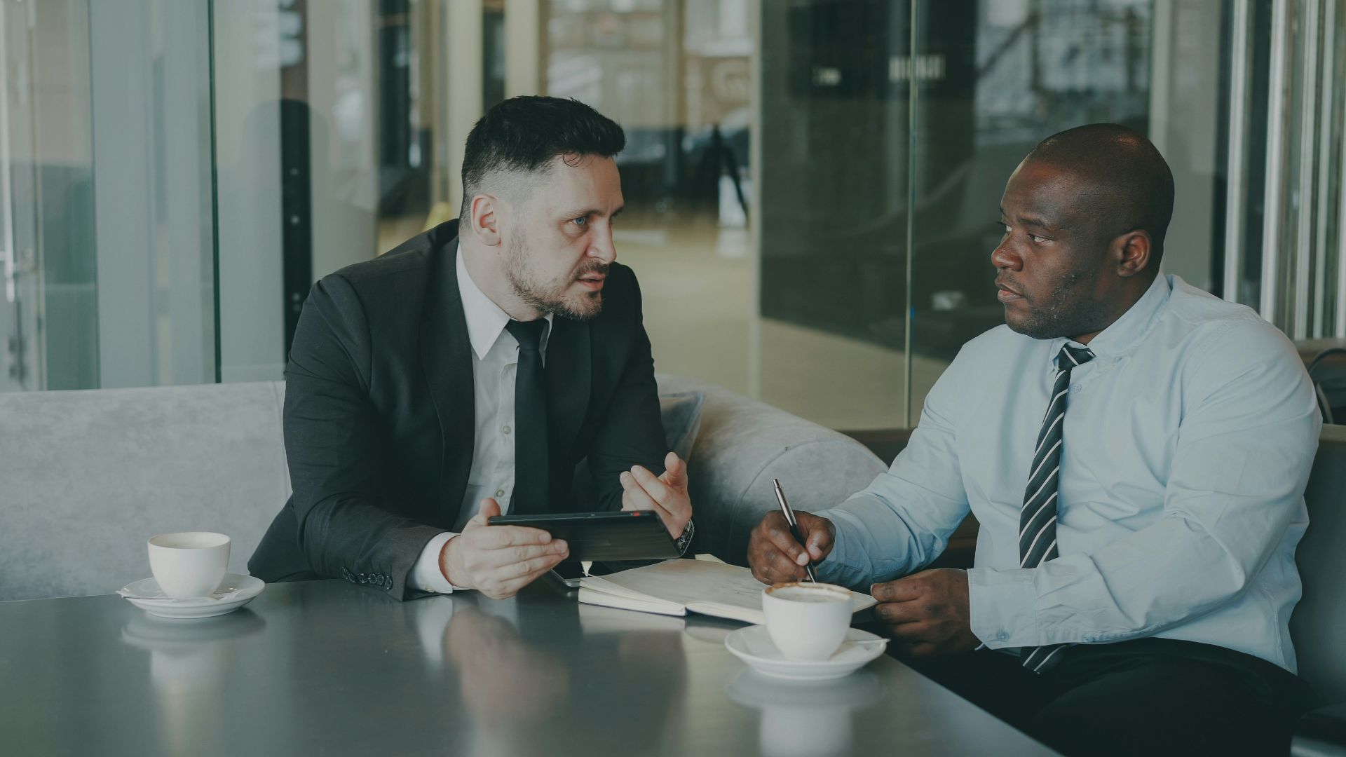 Two businessmen discussing work over coffee.