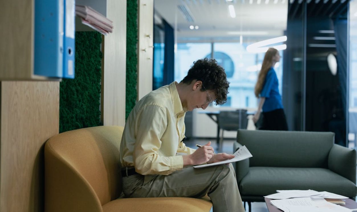 Man in Yellow Long Sleeves Sitting on Brown Couch