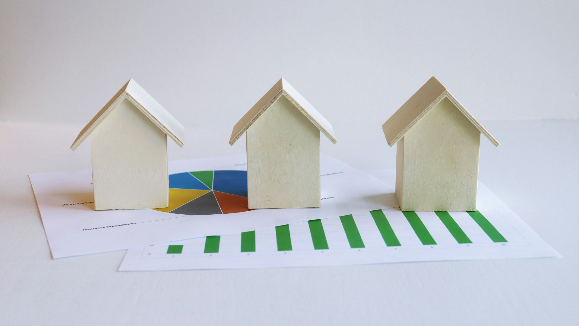 three small houses sitting on top of a piece of paper