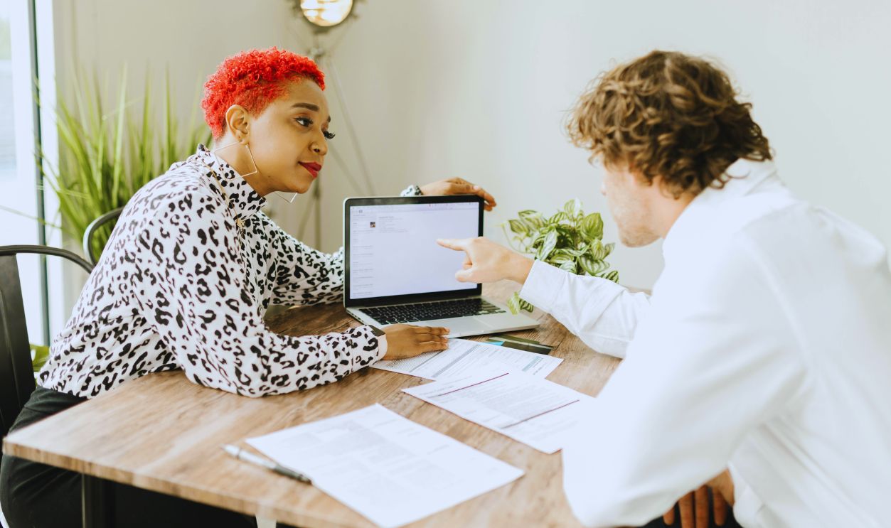 A Woman Showing a Laptop to a Person