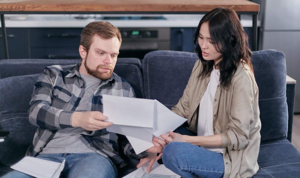 A Man and a Woman Checking on Some Tax Forms