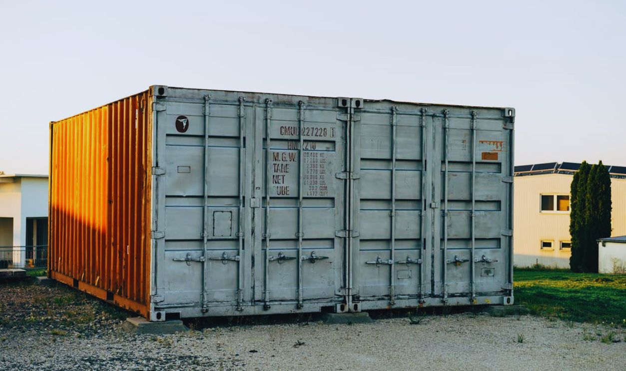 Two shipping containers sitting in front of a building