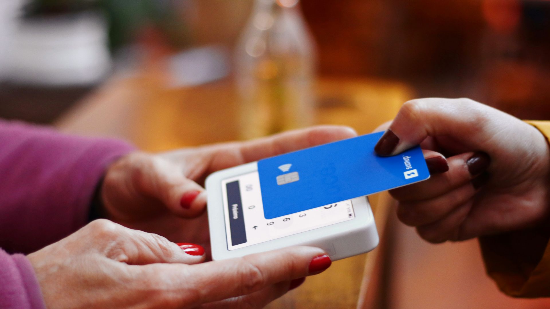 a person holding a credit card and a cell phone