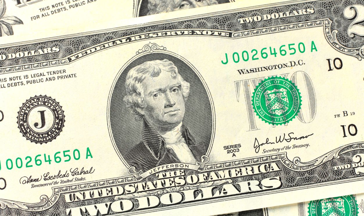 Several two US dollar bill sitting in a pile The United States two-dollar bill ($2) is a current denomination of United States currency. A portrait of Thomas Jefferson, the third President of the United States (1801–09), is featured on the obverse of the note. The reverse features an engraving of the painting Declaration of Independence by John Trumbull. photographed by Peter Dazeley Nov 2020 in his studio in London UK