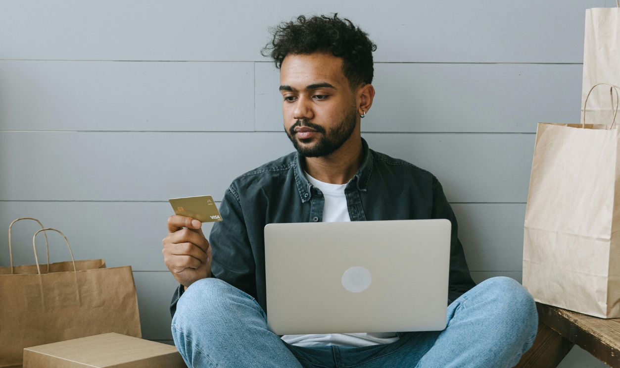 Man sitting on Ground looking at a Card