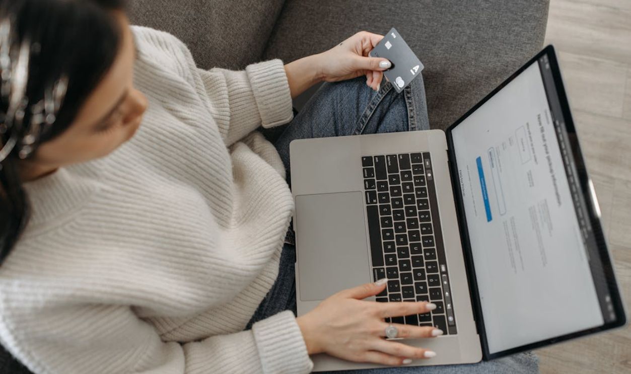 A Woman Using Her Laptop while Holding a Credit Card