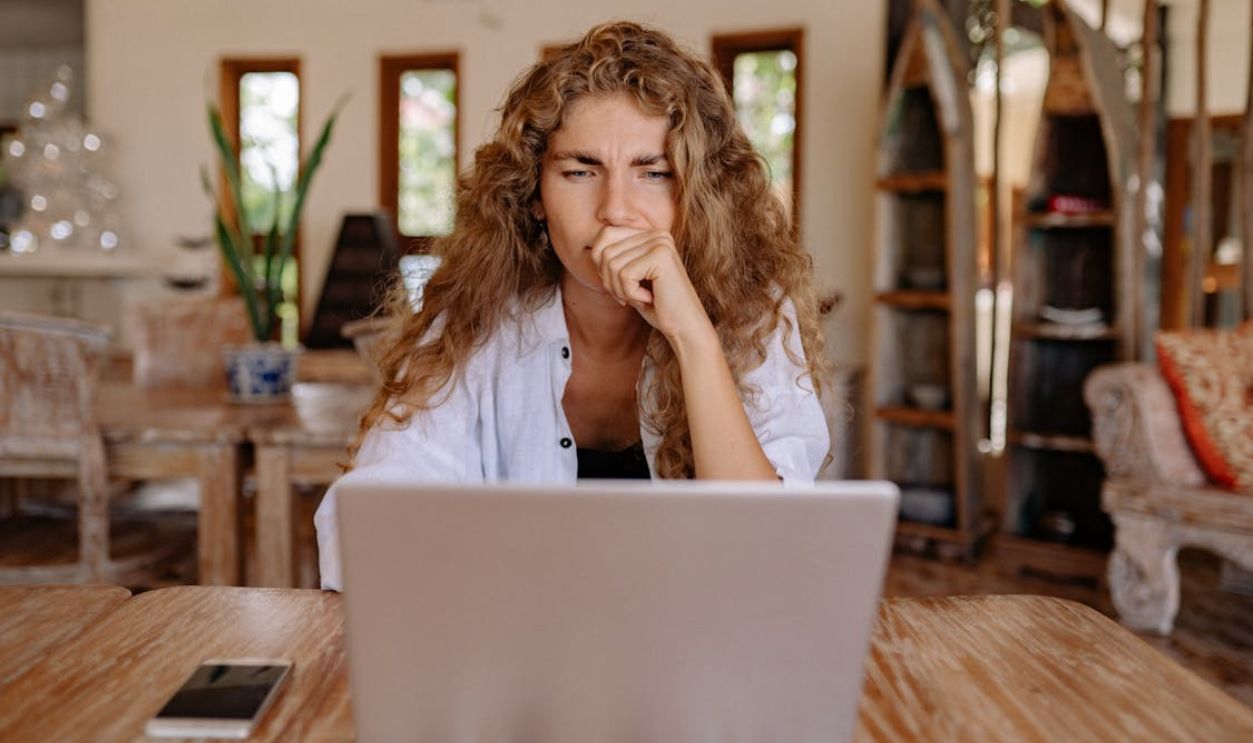 Photo of Woman Looking Serious While Using Laptop