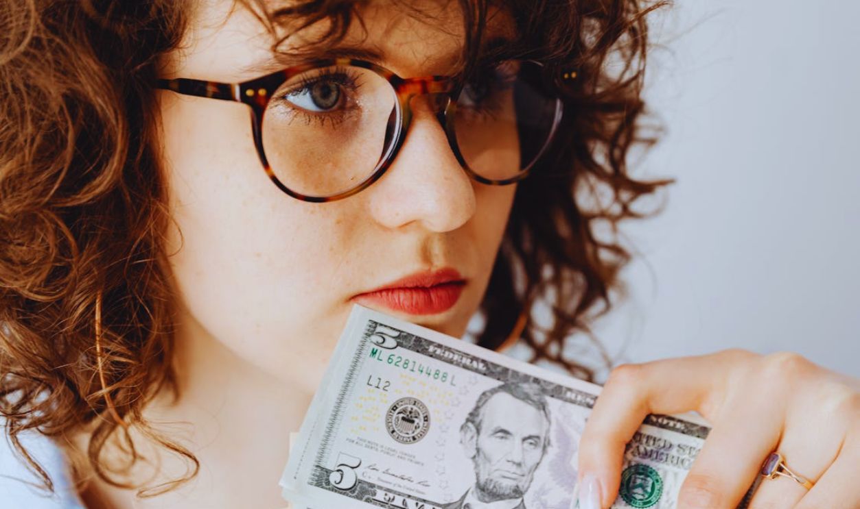 Woman Wearing Eyeglasses Holding Money