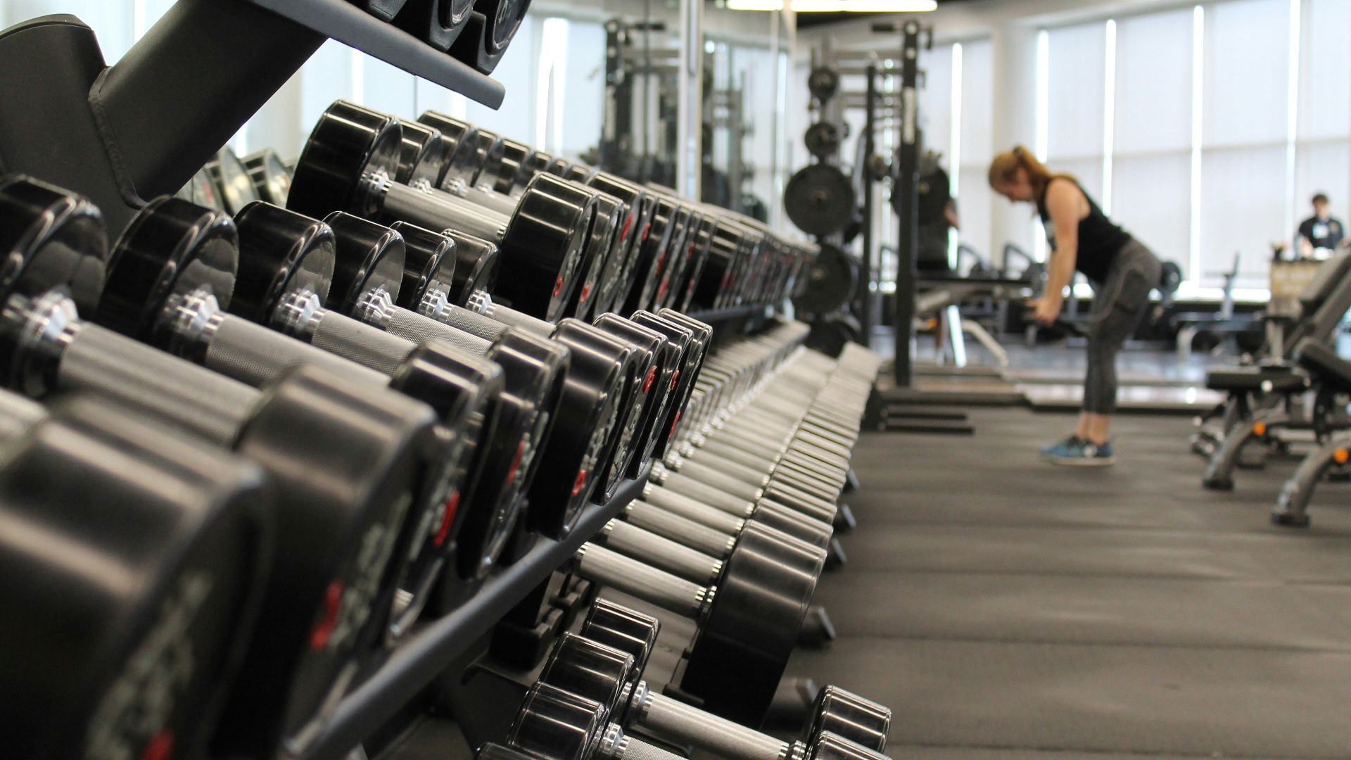 woman standing surrounded by exercise equipment