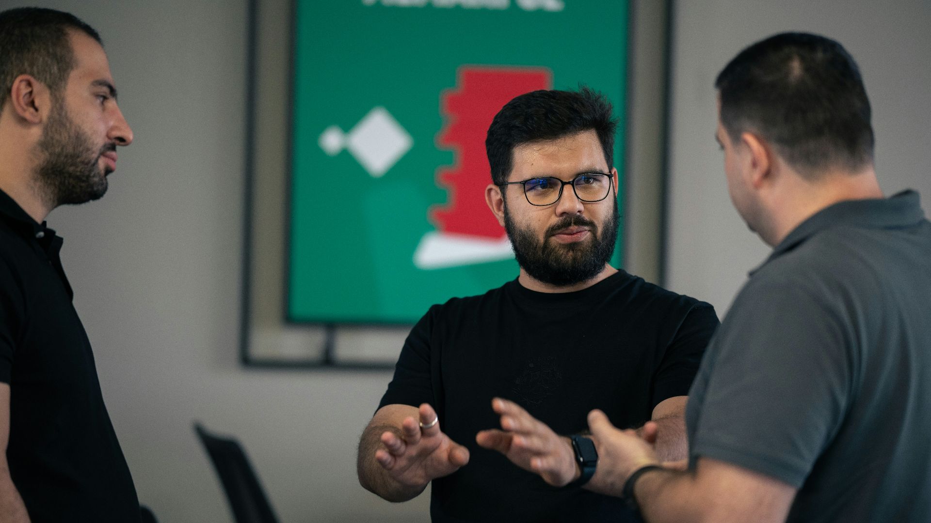 A group of men standing around each other in a room