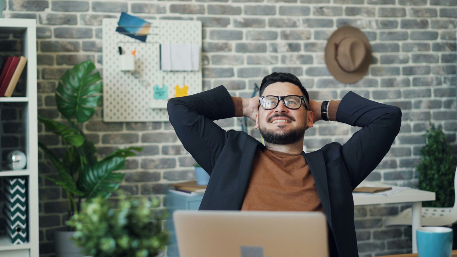 a man sitting at a desk with his hands behind his head