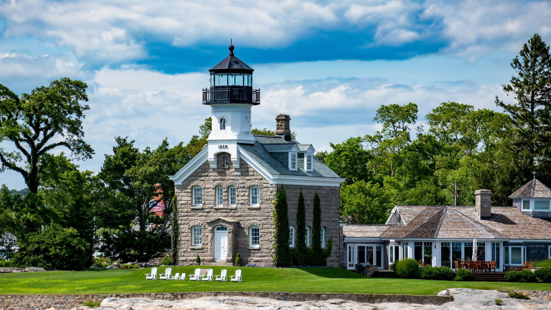a light house sitting on top of a lush green field