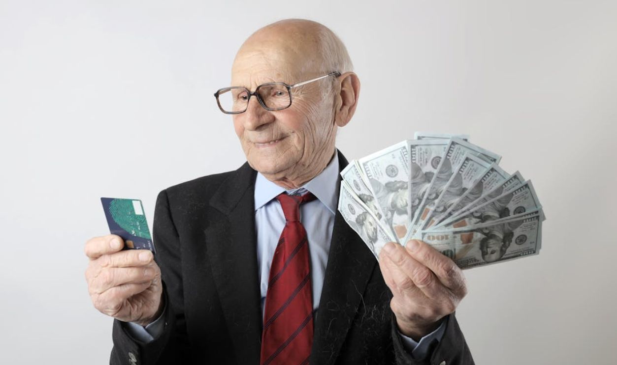 Man In Black Suit Holding Banknotes And Credit Card