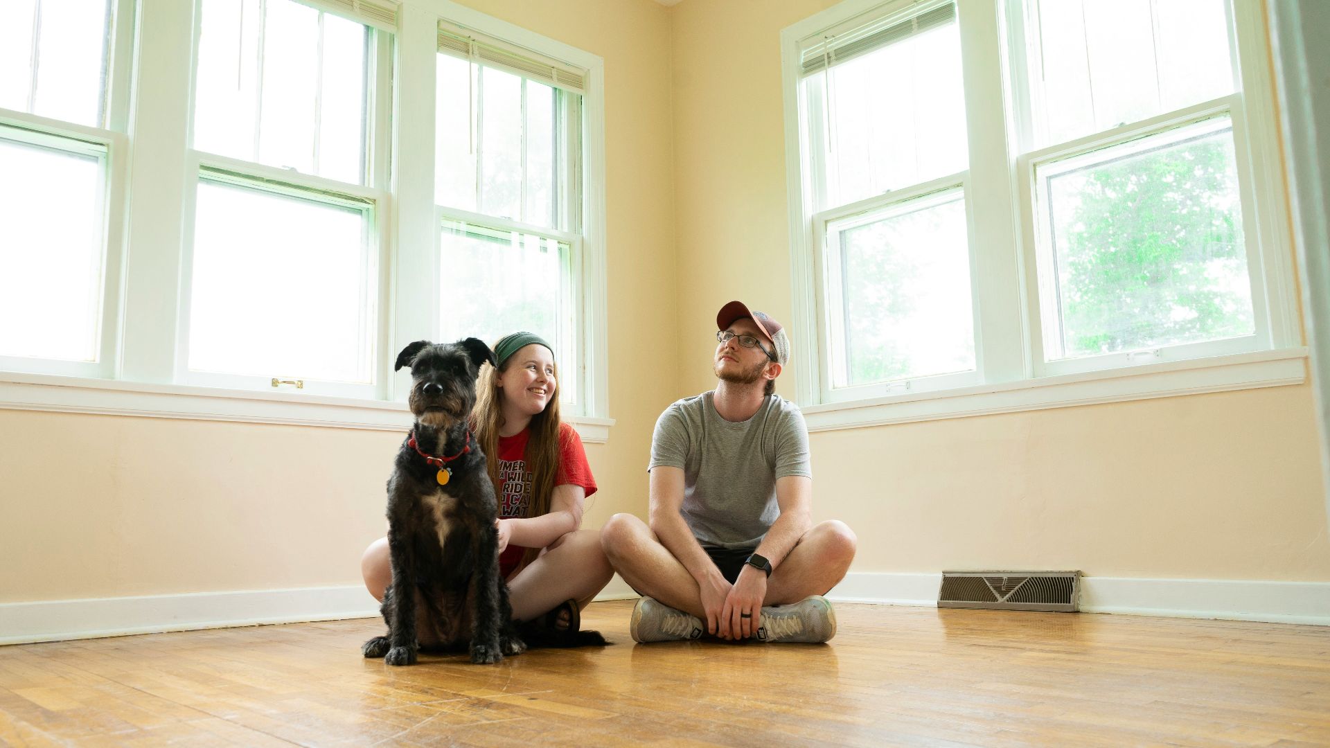 woman in gray shirt sitting on brown wooden floor
