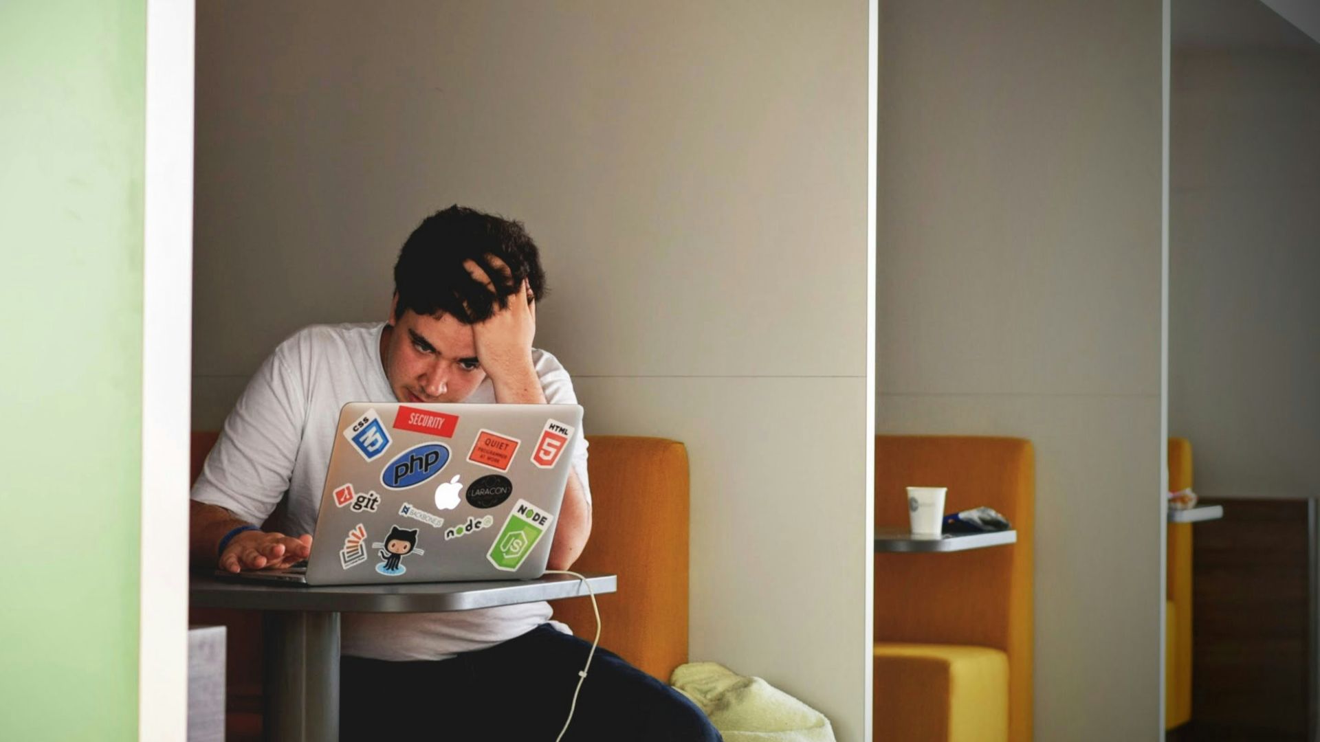 man wearing white top using MacBook