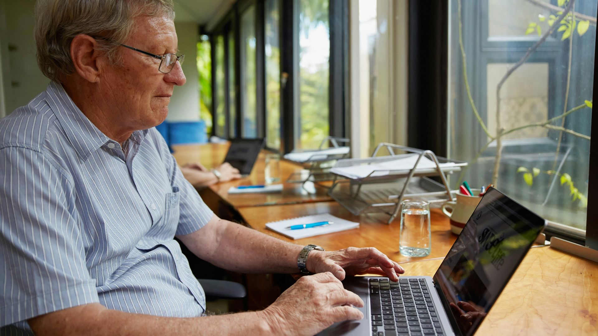 a man sitting at a table using a laptop computer