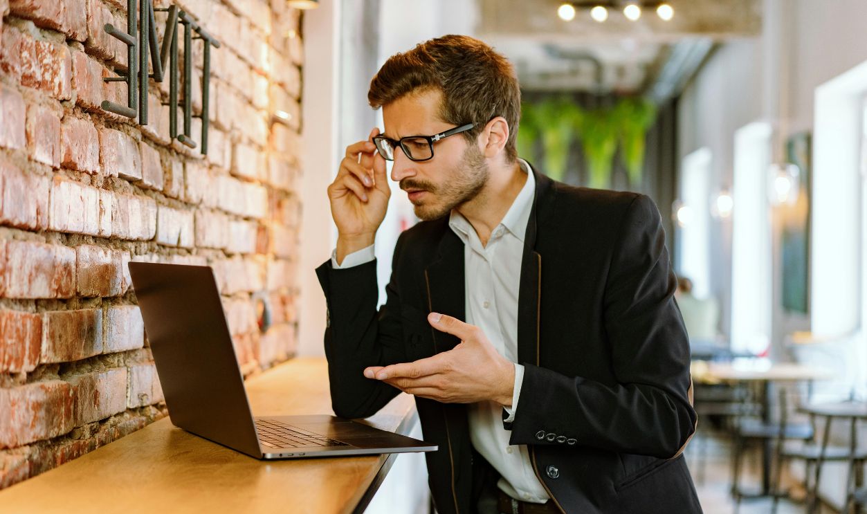 A Man in Black Jacket Using Laptop