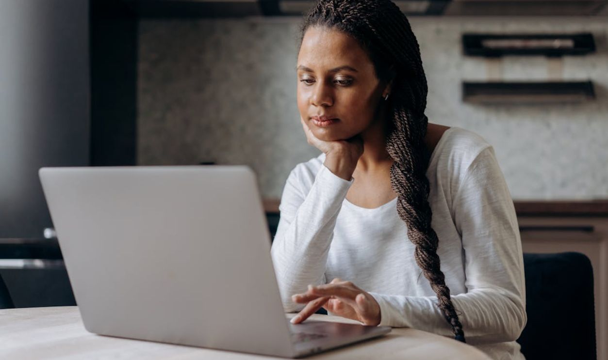 Woman Using her Laptop while her Hand under Chin