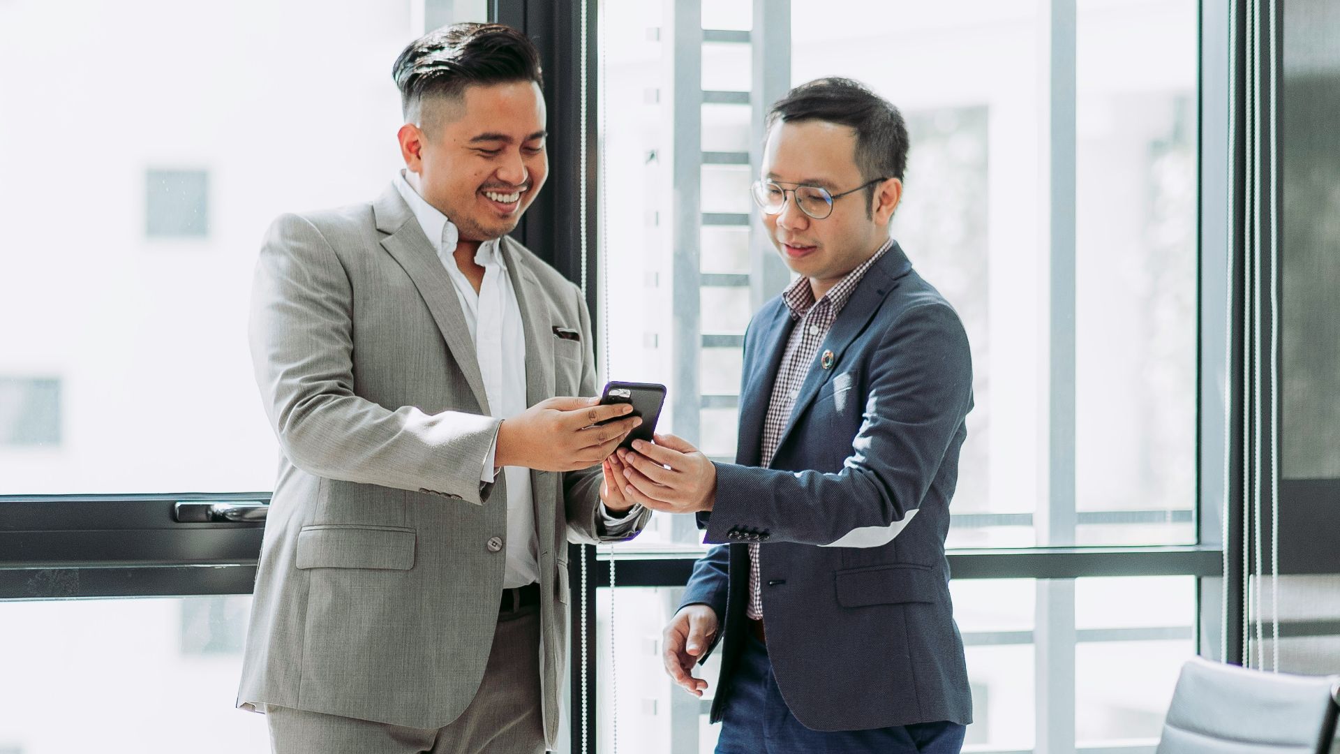two men shaking hands in a conference room