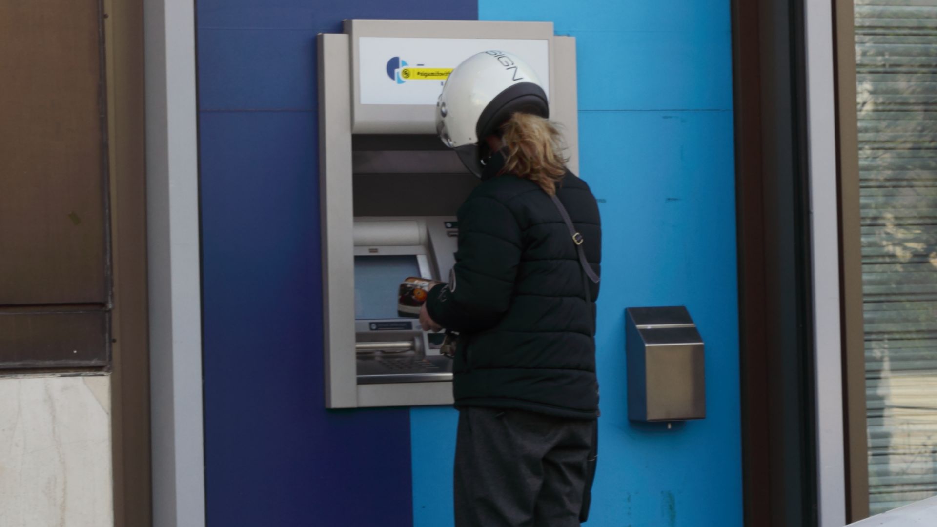 File:Person uses a bank's ATM in a street in Athens, Greece.JPG